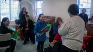 Group gathered in a room with dogs.