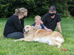Family spending time together with their golden retriever in a park.