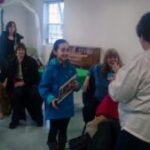 Group gathered in a room with dogs.