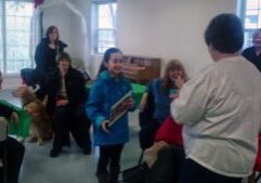 Group gathered in a room with dogs.